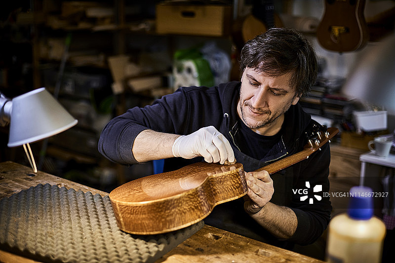 乐器制造者在他的工作室里制作尤克里里琴图片素材