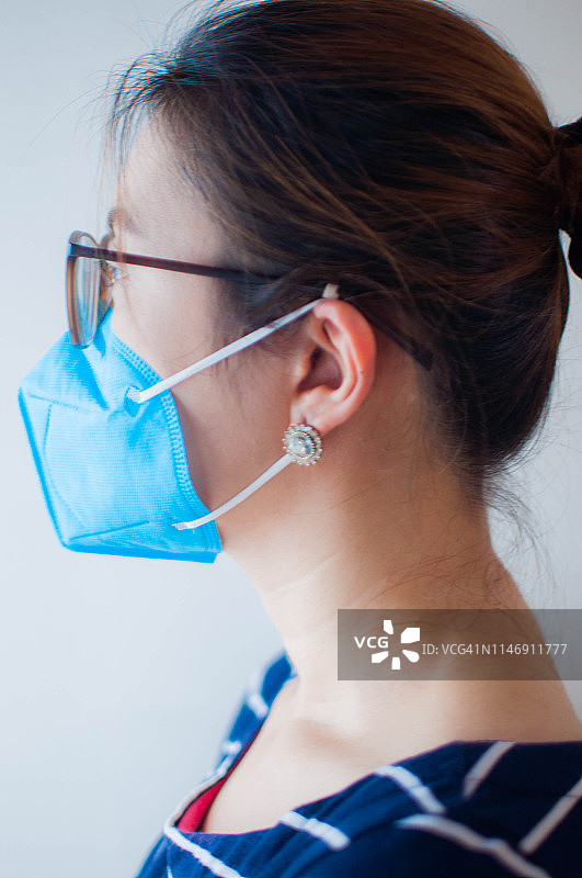 一位年轻女子戴着蓝色医用口罩图片素材