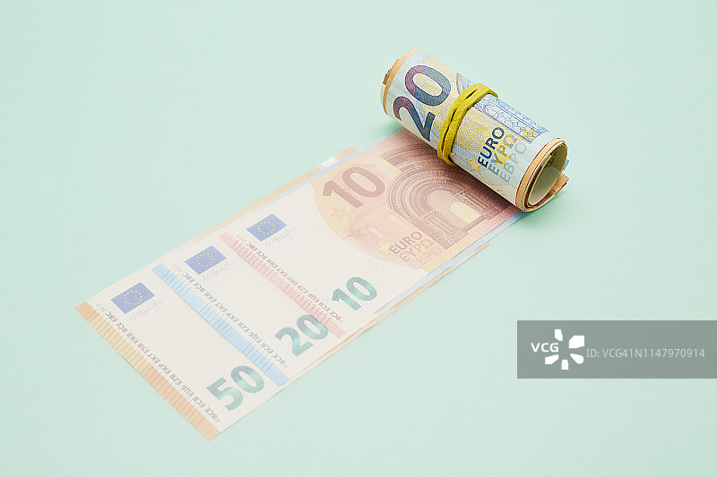 绿松石背景上的一卷欧元钞票图片素材