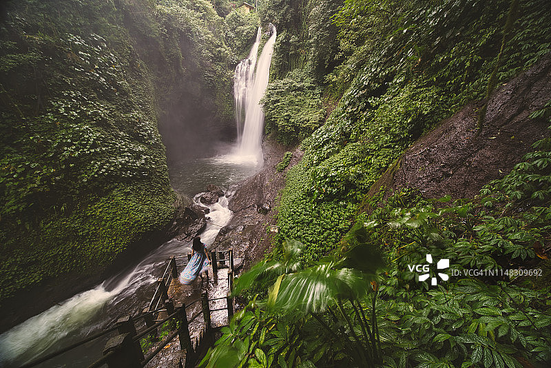 一位女孩站在印尼巴厘岛的灵岭瀑布前图片素材