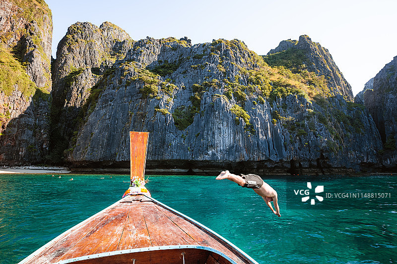 泰国皮皮岛，一名男子从船头潜水图片素材
