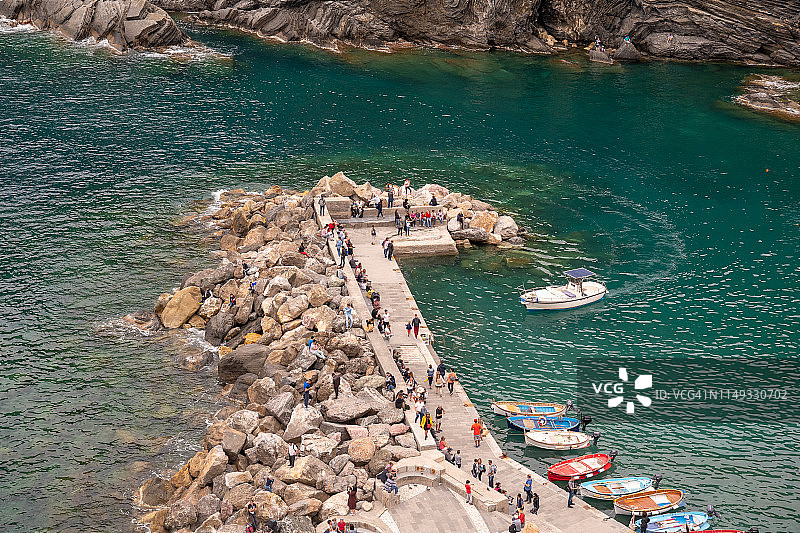 意大利利古里亚，联合国教科文组织世界遗产，Vernazza小港码头的高角度视角，游客，停泊的渔船和背景中的悬崖图片素材