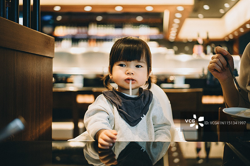 可爱的亚洲小女孩在餐厅吃面条图片素材
