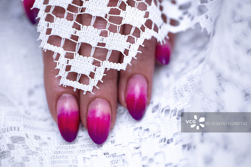 特写的女人的手指与指甲艺术美甲与霓虹灯粉红色图片素材