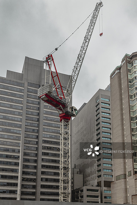 阴天里，加拿大多伦多市中心被摩天大楼包围的建筑起重机图片素材