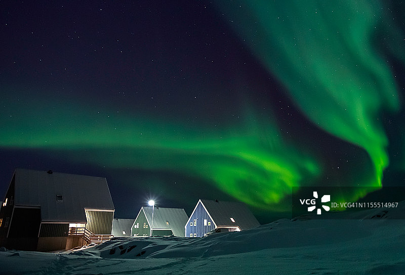 格陵兰努克郊区的北极村庄和因纽特人房屋上空的北极光图片素材