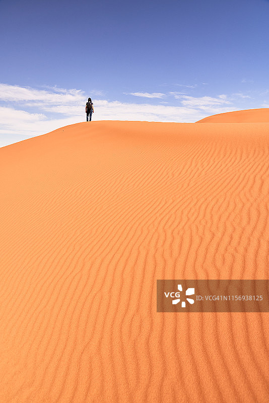 在北非摩洛哥的撒哈拉沙漠，一名女子在欣赏阳光下的美景图片素材