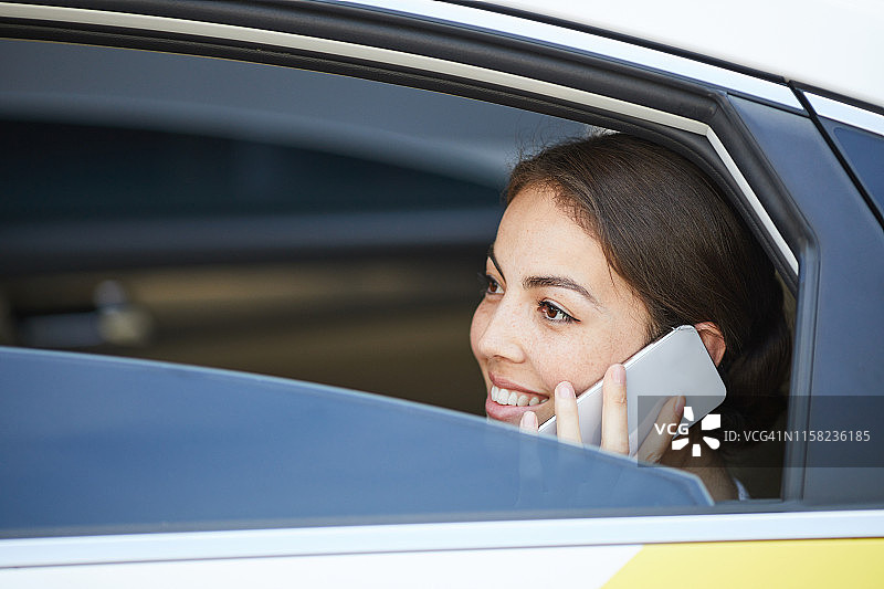 微笑的女人在车里打电话图片素材