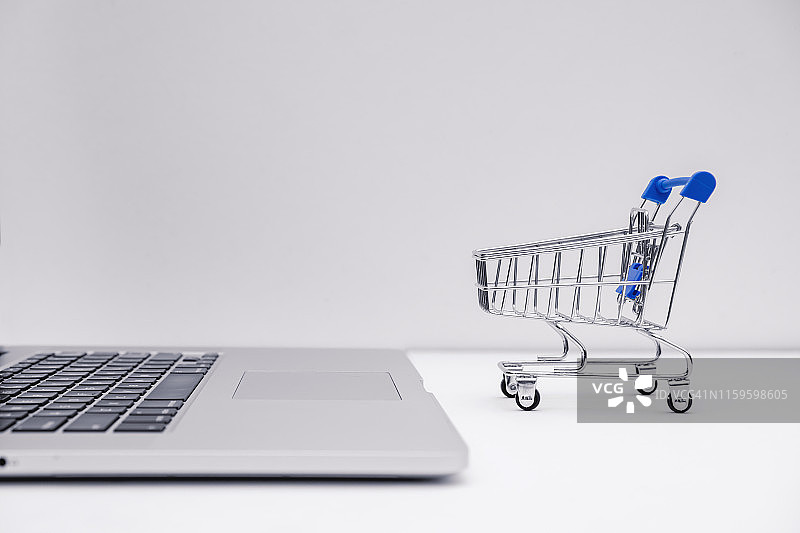 购物车和笔记本电脑。网上购物的概念。图片素材