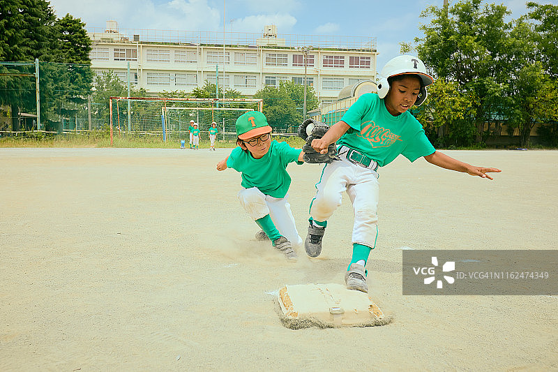日本儿童棒球运动员在场上奔跑图片素材
