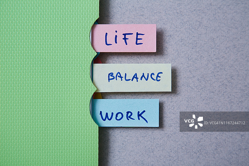 工作生活平衡选择理念。在笔记本上有题字的贴纸。图片素材