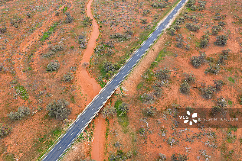 无人机俯瞰澳大利亚内陆的红土、干涸的河床和漫长的道路图片素材