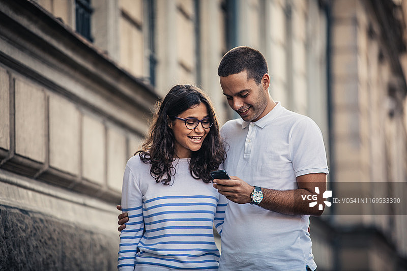 情侣在街上一起用手机图片素材