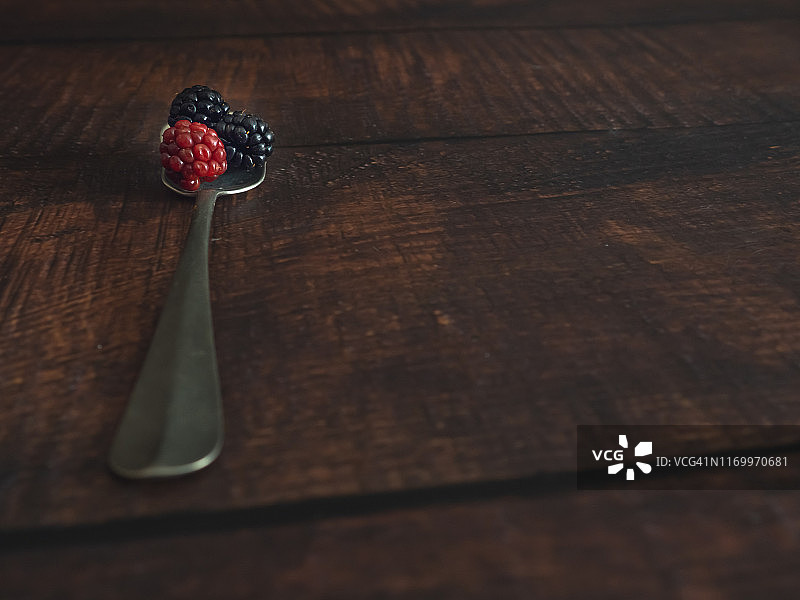 秋天的水果:一个老羊驼勺子和红色和黑色的黑莓图片素材