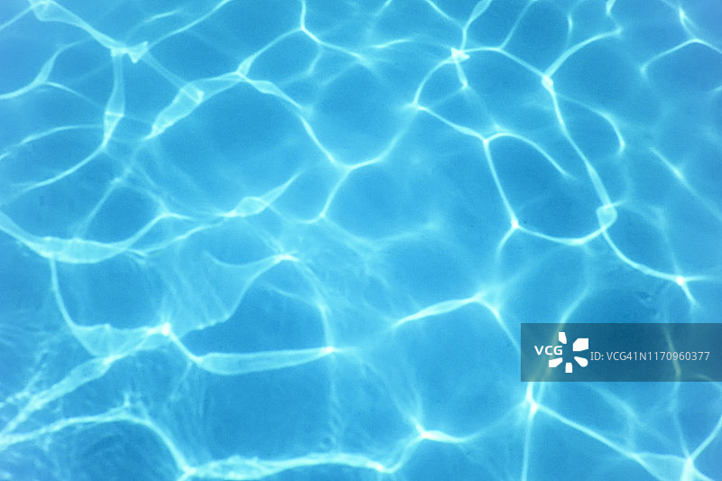 游泳池的水。水波纹。太阳反射背景。图片素材