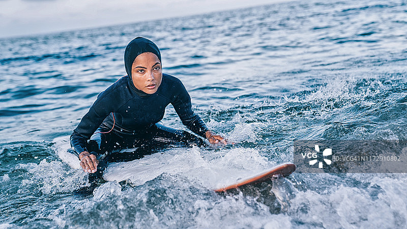 女冲浪者戴着头巾在海上图片素材