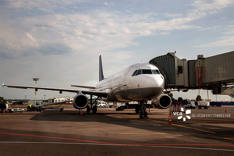 遥控装置与飞机相连。伸缩梯与飞机相连。机场工程系统工作。旅客登机和下飞机。套筒与飞机相连。图片素材