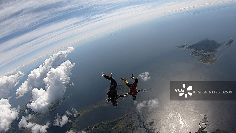 跳伞者在空中飞行，穿过晴朗的天空图片素材