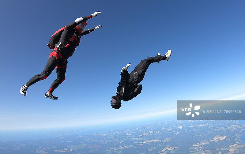 跳伞者穿过晴朗的天空，空中飞行图片素材