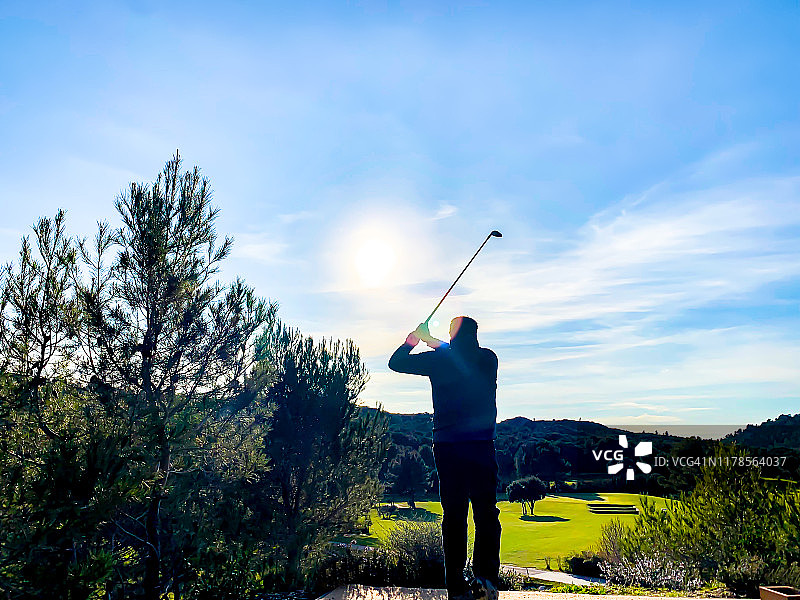 高尔夫球手在剪影与高尔夫挥杆对太阳图片素材