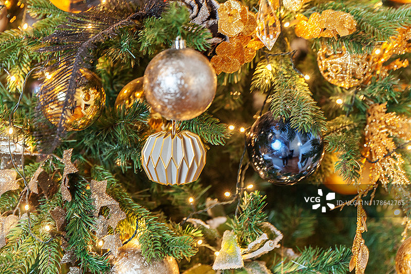 经典的圣诞新年装饰新年树用金色的装饰品玩具和球图片素材