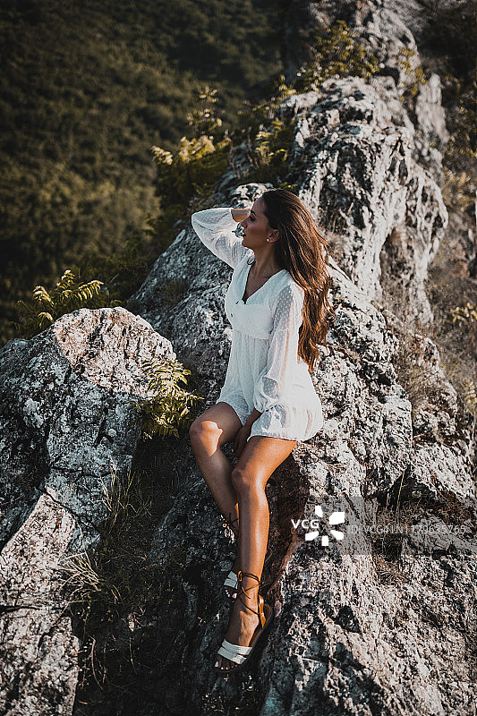 美丽的女人穿着衣服在山上放松图片素材