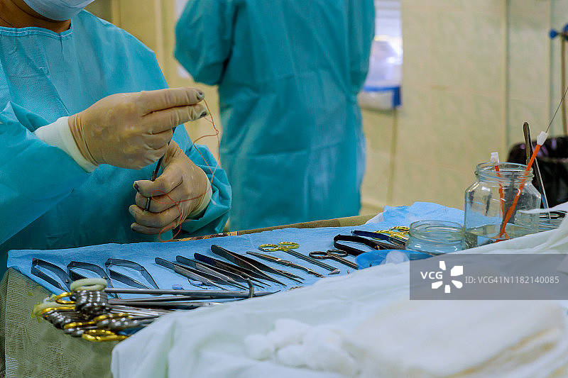 消毒过的手术器械工具放在蓝色的手术台上。图片素材