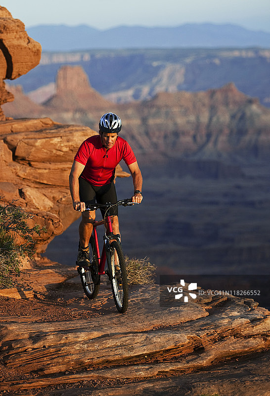 骑车人在犹他州巨大的峡谷边缘骑着山地车图片素材