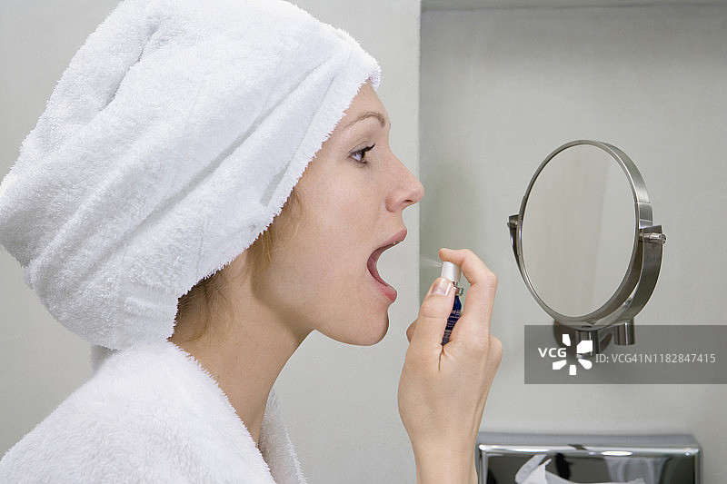 女人在浴室里喷口气清新剂图片素材