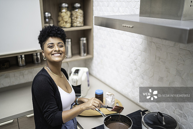 一个年轻女子在家做饭的肖像图片素材