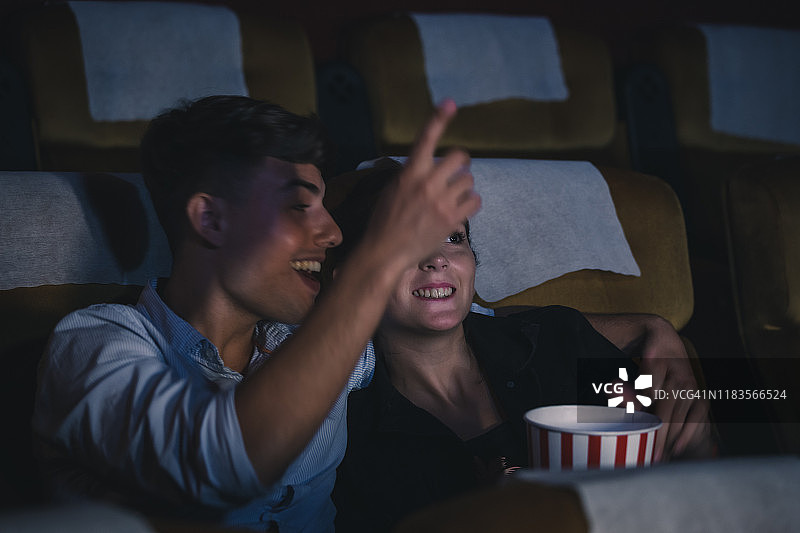 一对年轻夫妇在电影院幸福地看电影图片素材