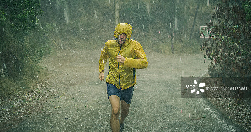 运动员在极端天气条件下慢跑。冰雹和雨图片素材
