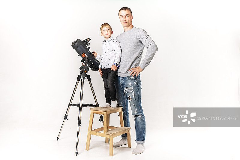 父亲教儿子如何使用望远镜。图片素材