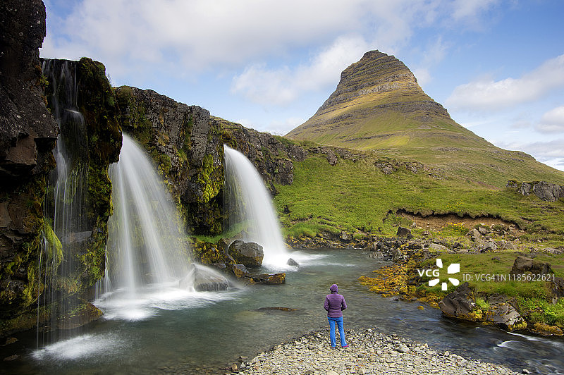 一位女士在欣赏 Kirkjufell，Kirkjufellsfoss，Snaefellsnes 半岛，Grundarfjörður，Vesturland，冰岛。图片素材