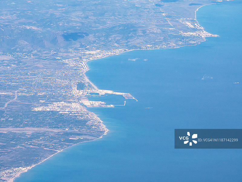 从飞机的窗口透过云层的西班牙海岸的风景鸟瞰图图片素材