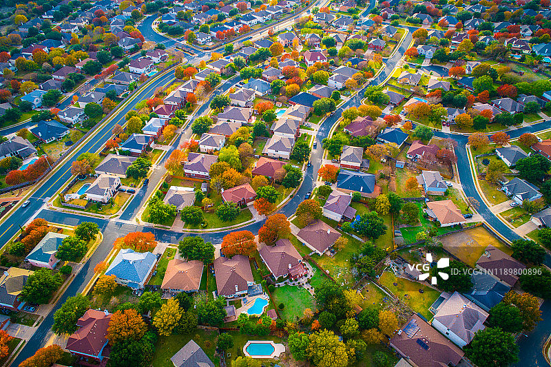 弯曲的现代道路和发展空中无人机上方的秋天颜色郊区现代住宅开发图片素材