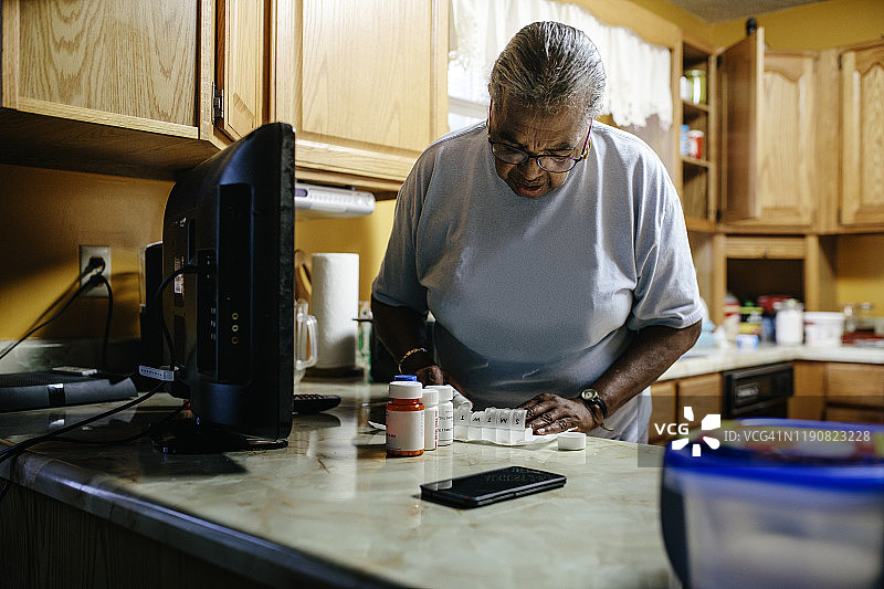 年长黑人妇女整理她的药物图片素材