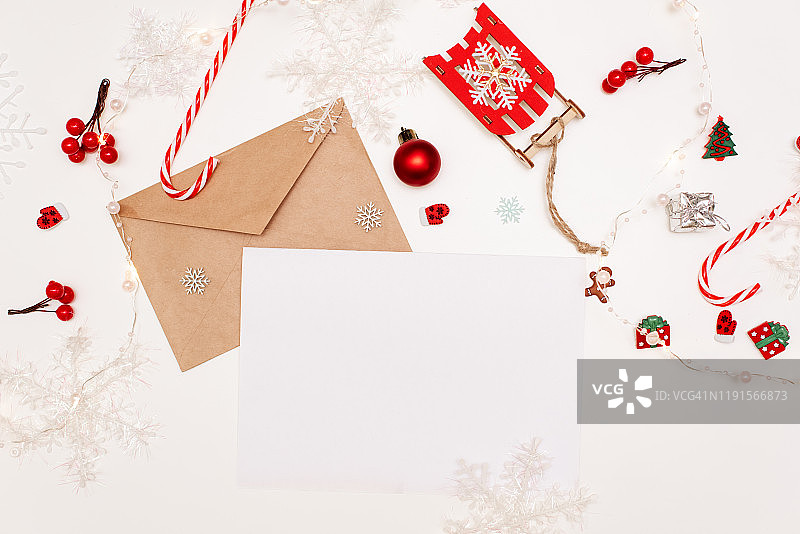 孩子给圣诞老人写了一封信。孩子的手，纸，铅笔和圣诞装饰在一个木制的表面。新年和圣诞节的概念。俯视图图片素材
