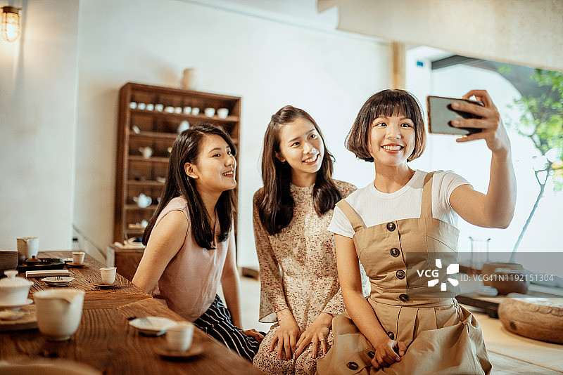 中国千禧一代女性享受着喝茶和自拍的时光图片素材