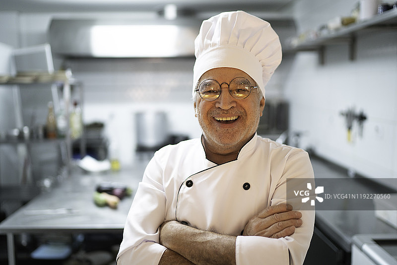 高级厨师在厨房微笑的肖像图片素材