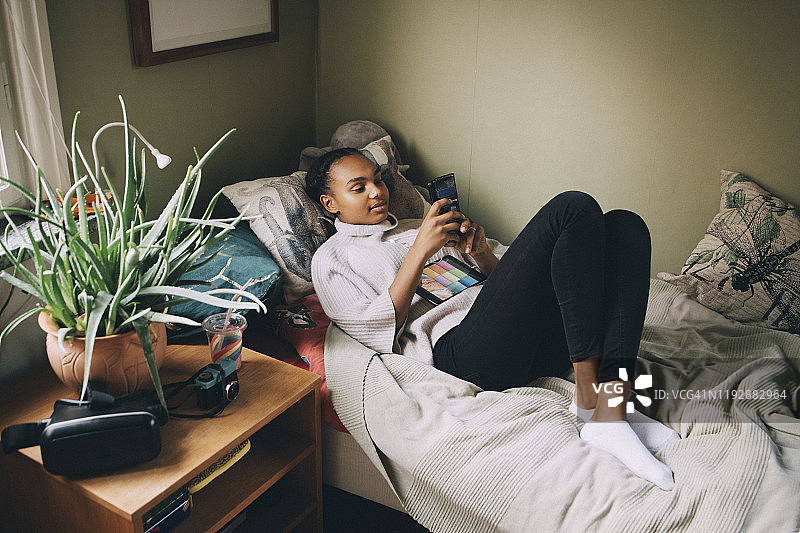 女性青少年躺在家里的床上使用手机图片素材