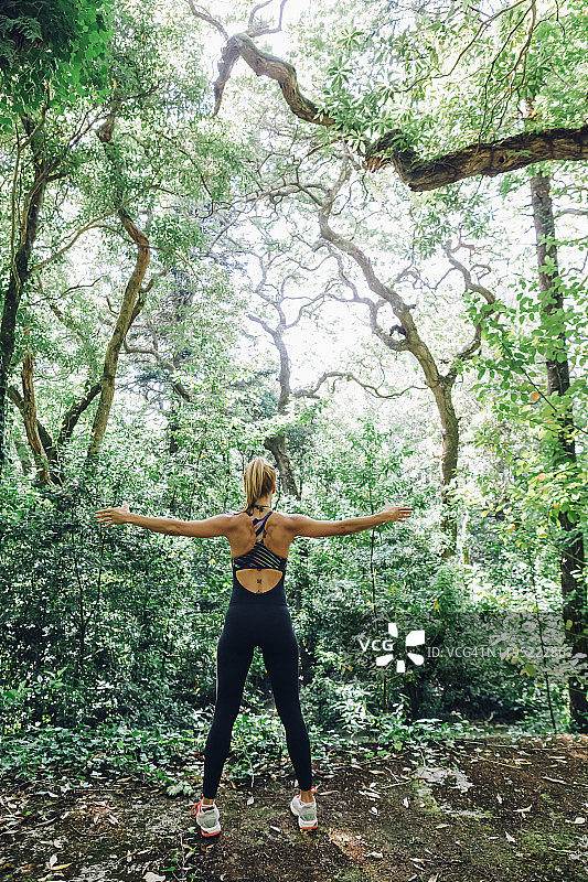 适合女性私人教练锻炼，在森林里伸展手臂图片素材