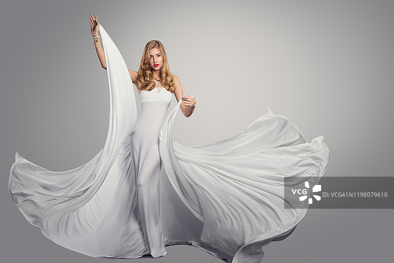 女人跳舞长白色丝绸连衣裙，时装模特在飘扬的长袍，美丽肖像图片素材