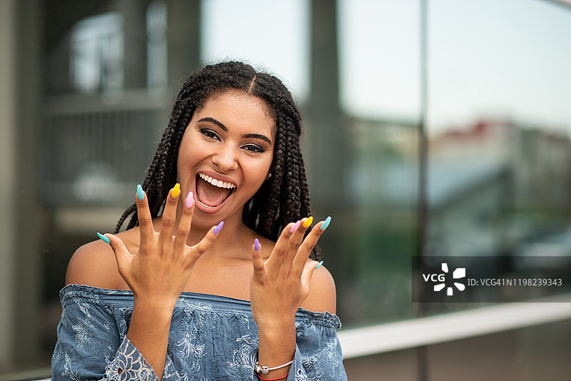年轻兴奋的女人，涂着五颜六色的指甲油图片素材