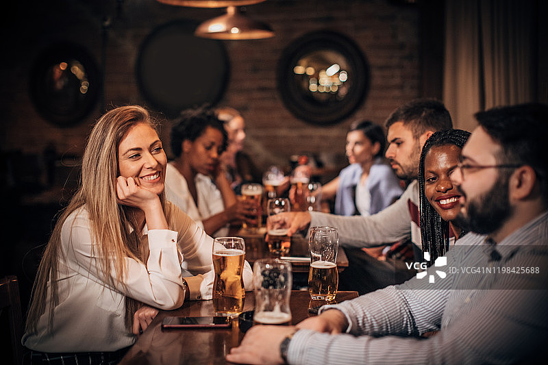 现代人一起在酒吧里喝啤酒图片素材