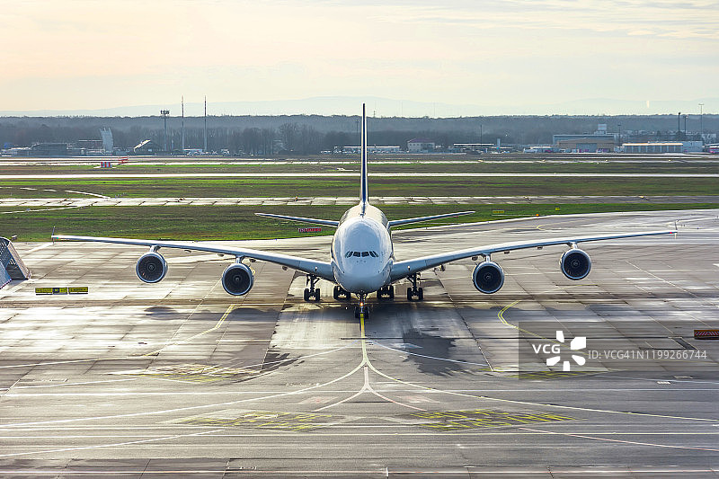 一架大型飞机前视图转向轨道和着陆后停在机场。图片素材
