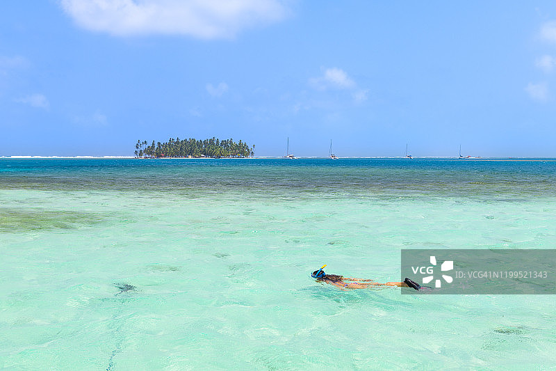 年轻女子浮潜在碧绿的水中。圣布拉斯群岛，巴拿马图片素材