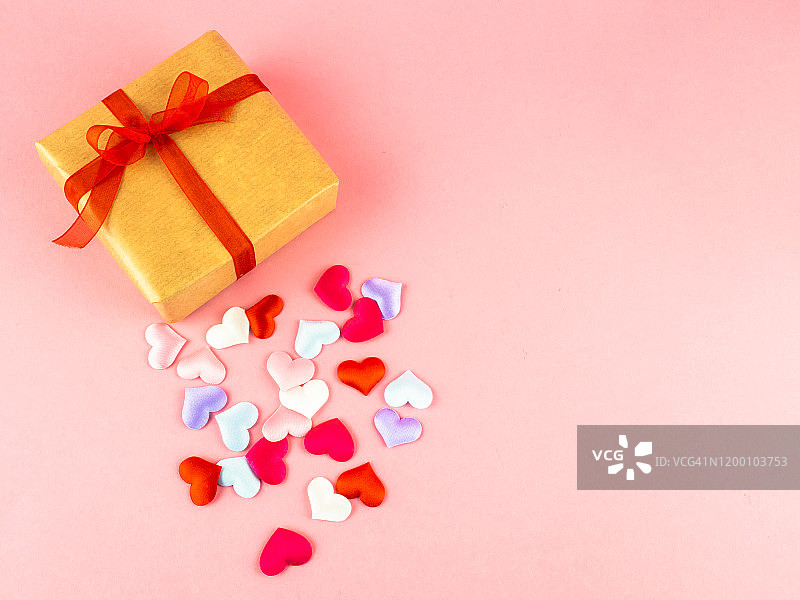 爱情和浪漫主义的概念。一个有丝带、红色蝴蝶结和彩色心形的礼品包图片素材