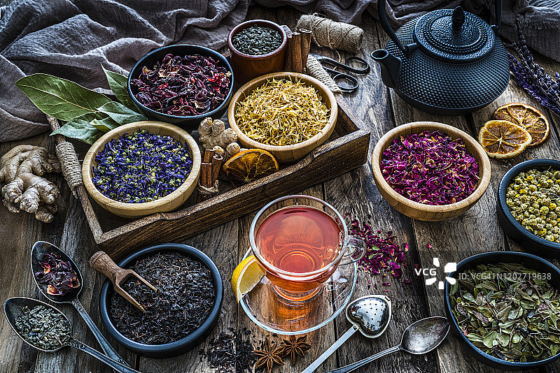 花草茶:各种各样的干茶叶和花从上面拍摄在质朴的木桌上图片素材