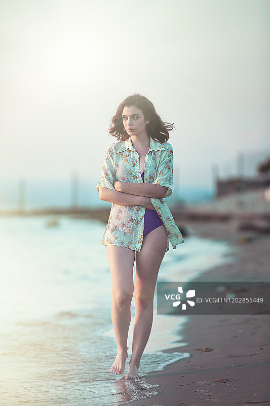 一个抑郁的年轻女人独自走在海滩上图片素材